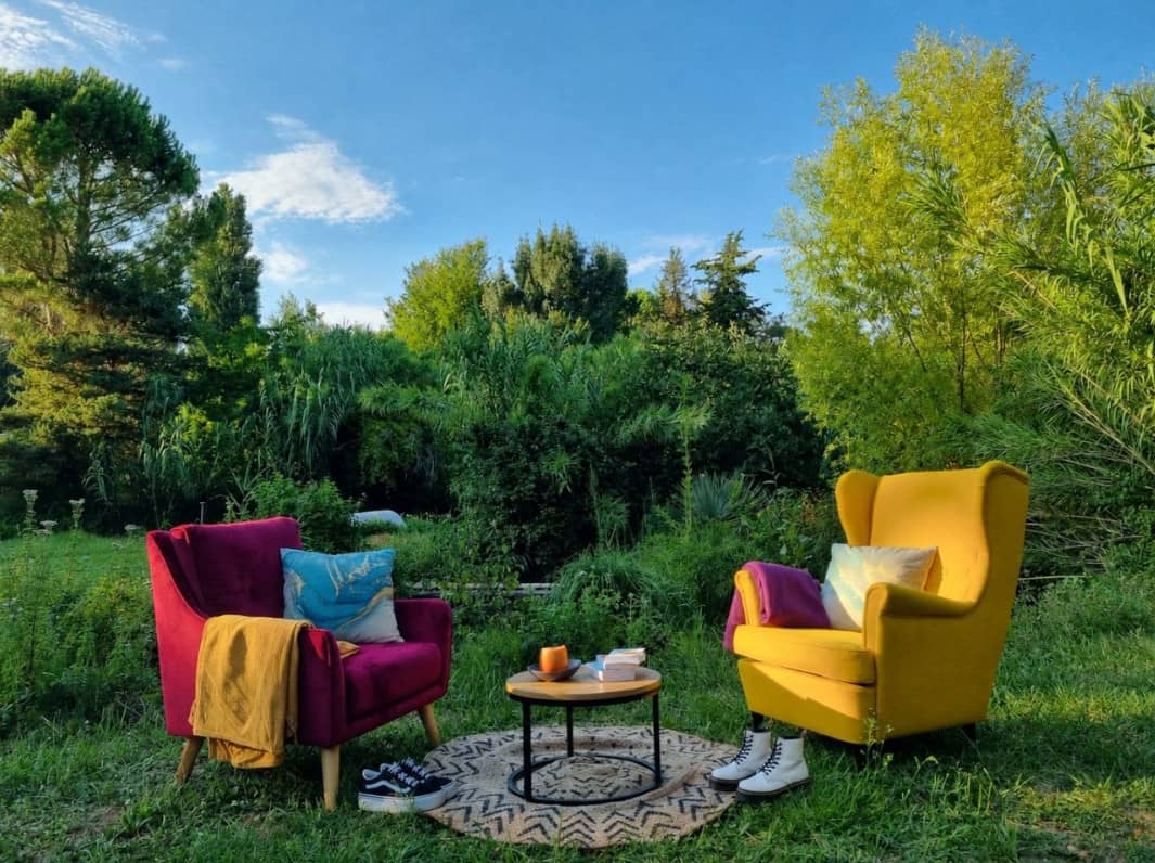 Deux fauteuils colorés face à face dans un jardin ensoleillé, espace de séance en extérieur